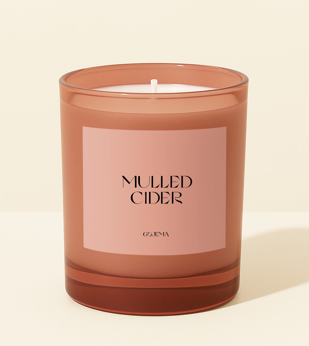 Candle with 'Mulled Cider' label on a beige background